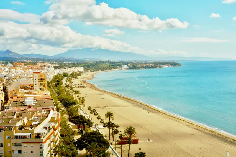 La Rada beach and promenade in Estepona with the mountains behind